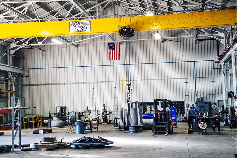 Interior view of the SKF-certified pump repair facility in Tampa, FL, featuring a 10-ton overhead crane, workstations, and pump repair equipment.